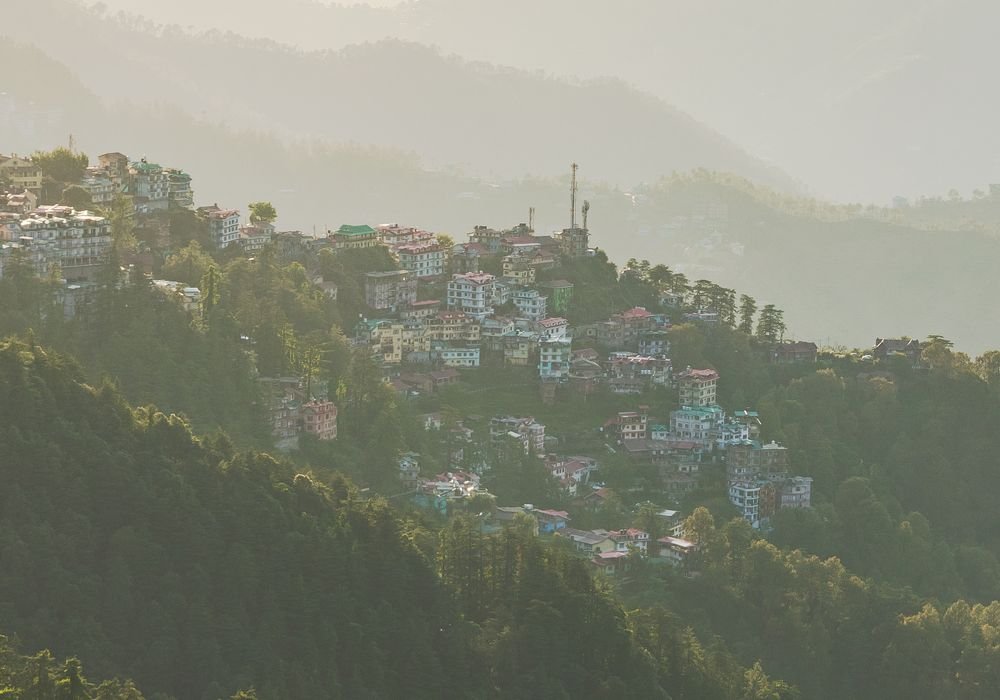 A Himalayan hill town stacked up the slope in the haze