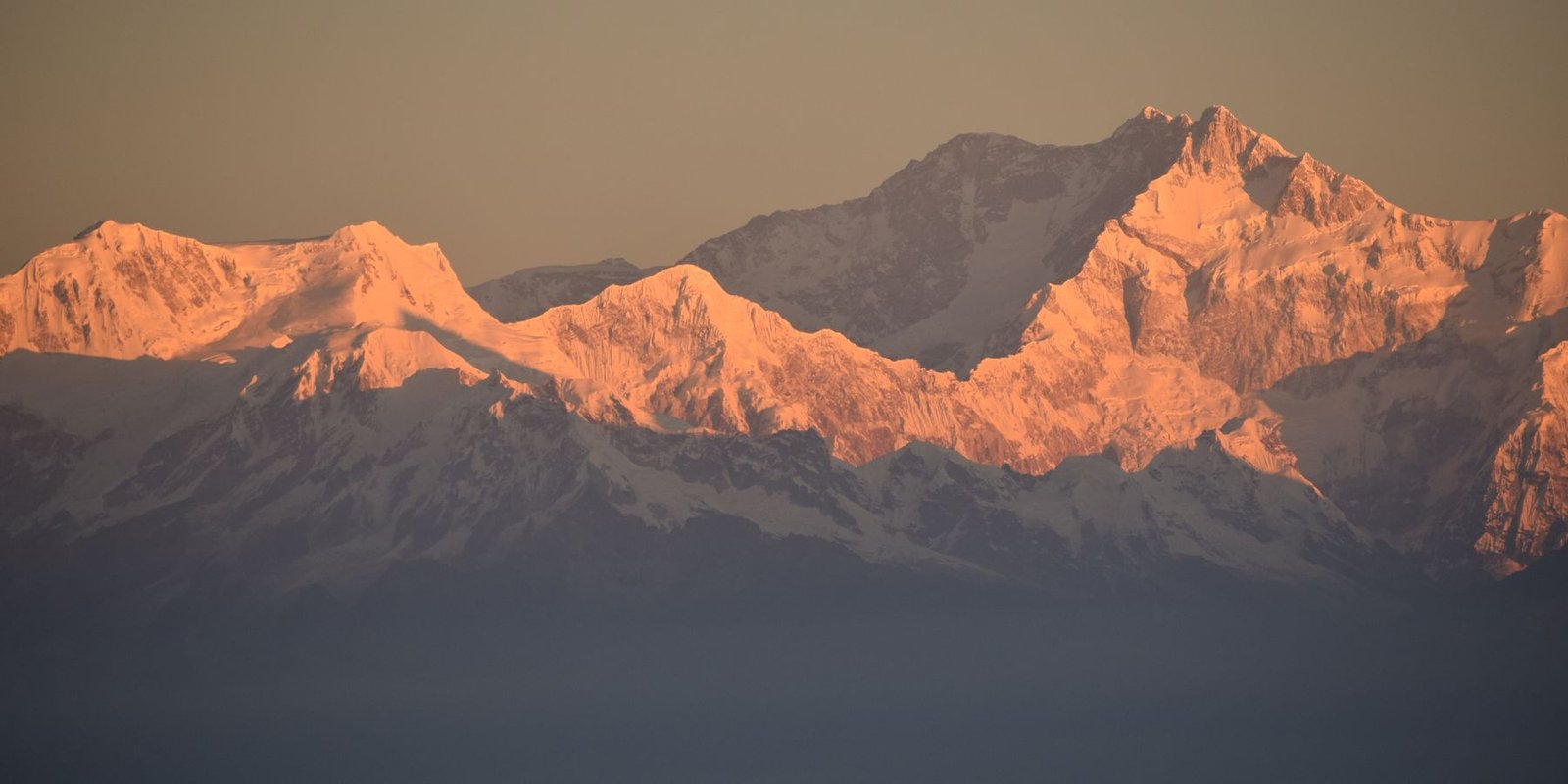 Snow peaks lit orange at sunrise