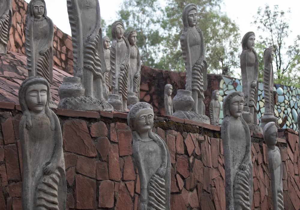 Mosaic figures lining a wall at the Rock Garden in Chandigarh
