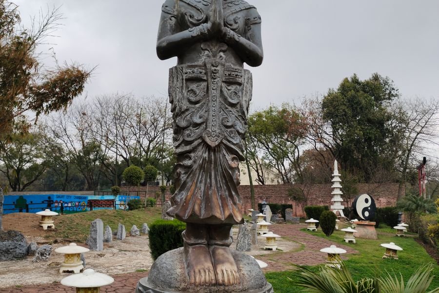 A sculpted figure in a garden made from recycled material