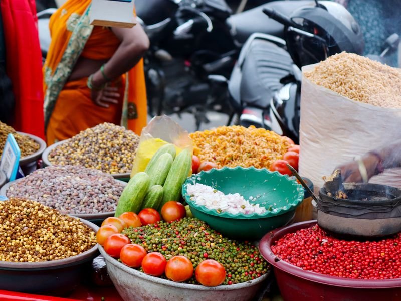 An Indian market stall piled with spices, pulses and vegetables