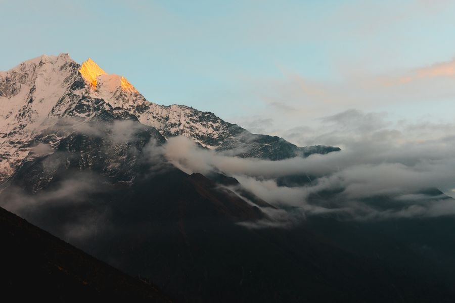Snow peaks rising above a layer of cloud