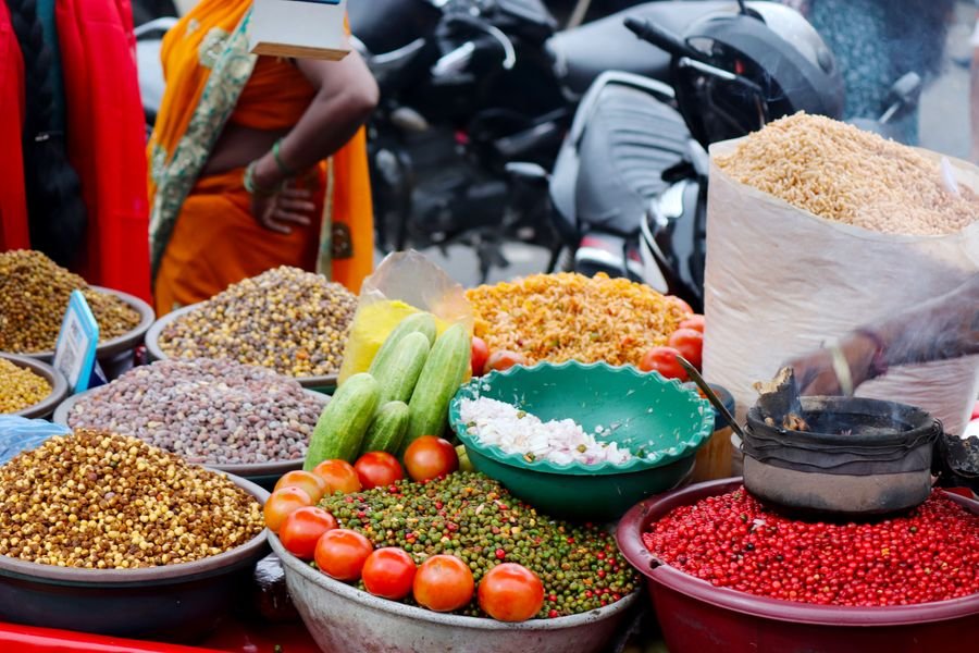 A street food stall piled with spices and vegetables