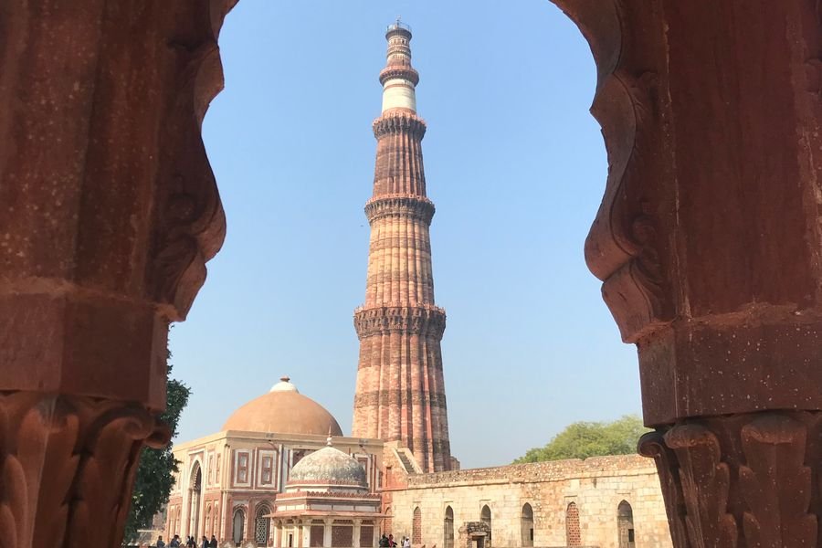 Qutub Minar in Delhi framed by a sandstone arch
