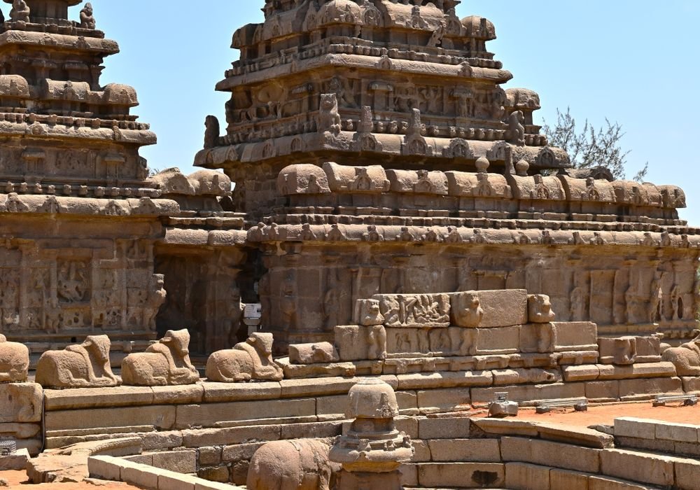 Rock-cut temples with carved stone animals beside them