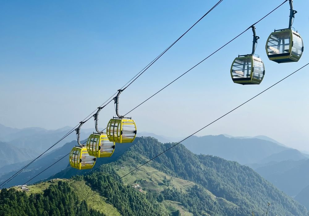 Cable cars crossing a green hillside